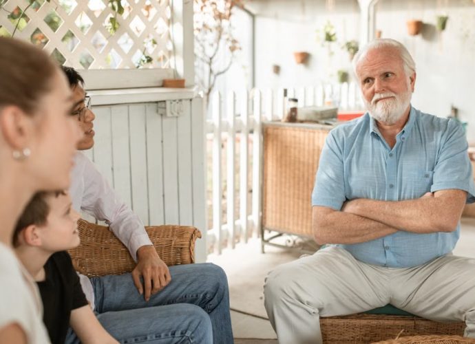 Family gathered indoors, engaged in conversation with a focus on bonds and togetherness.